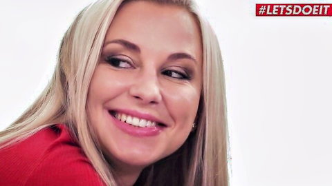 Smiling blonde in red top from LETSDOEIT sensual lesbian scene