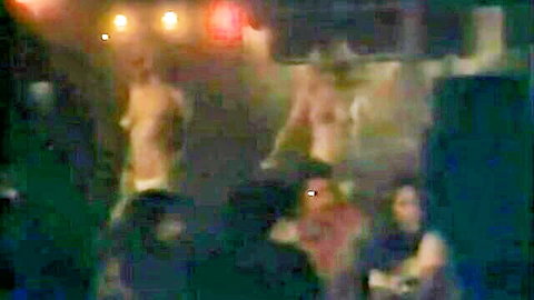 Blurry JAV group nude scene with multiple figures in dim red lights