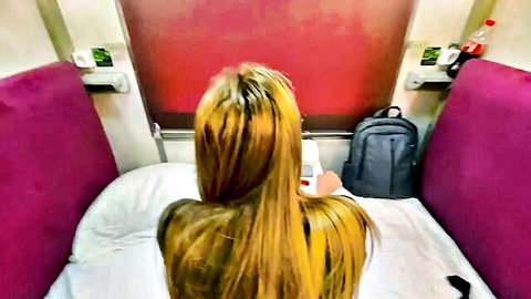 Alina Rai with long blonde hair in train bunk from behind