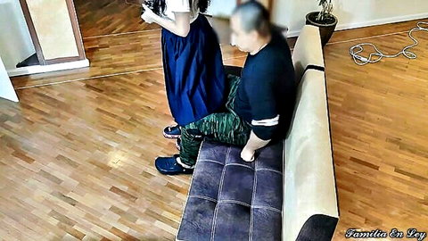 Young step niece in skirt stands over older man on couch, teasing touch
