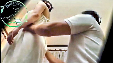 Asian woman in white dress gets sensual arm and back massage