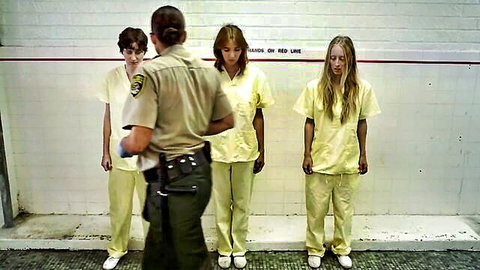 Sheriff facing lineup of three women in yellow prison uniforms