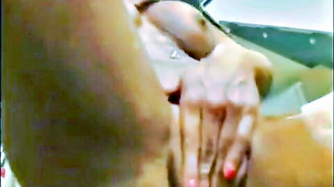 Blurry close-up of woman fingering her wet pussy with red nails
