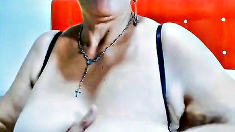 Mature woman with large natural breasts and cross necklace in black lingerie