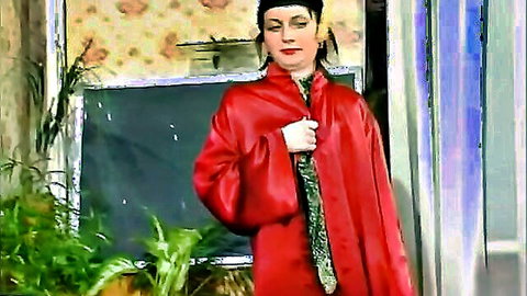 Mature teacher in red satin robe showing cleavage in classroom