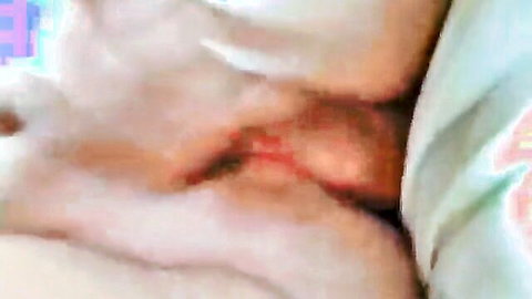 Close-up of mature woman's wet pink pussy spread open showing swollen inner labia and clit