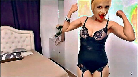 Muscular blonde MILF flexing biceps in sheer black lace lingerie showing big tits