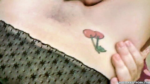 Mature woman's hairy pubic mound with cherry tattoo under sheer black lingerie