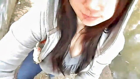 Asian beauty in open hoodie showing cleavage outdoors POV