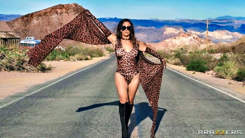 Cherie DeVille in leopard print bodysuit posing seductively in desert