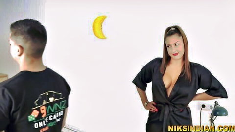 Young guy gazes at busty redhead MILF in open black robe, teasing cleavage