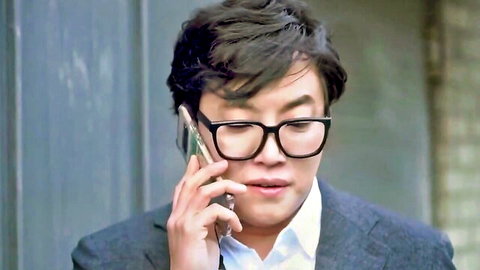 Handsome Korean man in glasses and suit talking on phone intensely