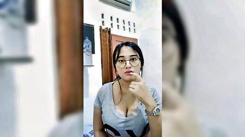 Acha Indonesian beauty in low-cut gray t-shirt showing deep cleavage