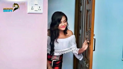 Hot Desi brunette in off-shoulder top and plaid skirt, teasing at door