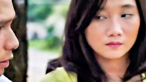 Intimate close-up of Asian couple outdoors, man and woman gazing at each other