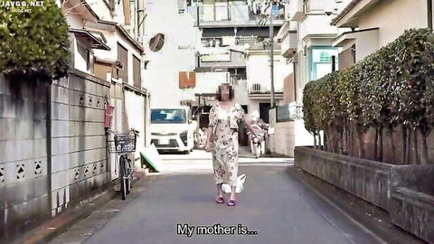 Petite Japanese mom in floral dress walks small dog down narrow urban alley