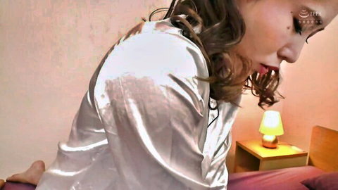 Miho Tsuno in silky white robe, seductive side pose on bed in JAV NDRA-101