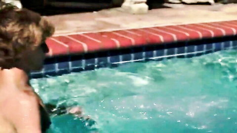 Hot twink lounging poolside, showing toned bare back in steamy gay scene