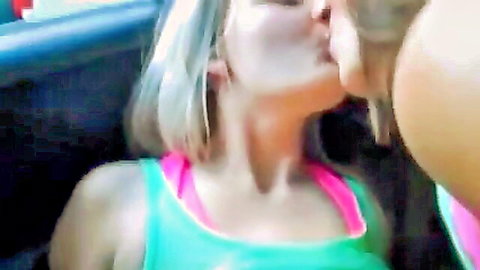 Two young blondes kissing passionately in car