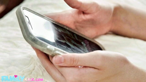 Amber Moore in Daddy's Favorite #3: woman's hands holding phone on bed