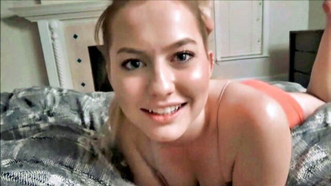 Blonde Britney Light smiling seductively in orange lingerie on bed