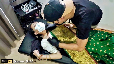 Saanvi Bahl in traditional sari getting neck tattooed by artist