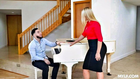 Thick blonde MILF in red top and black skirt seducing seated man