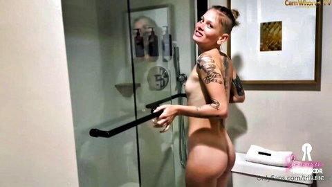 Tattooed blonde Sammmnextdoor nude in shower, smiling over shoulder
