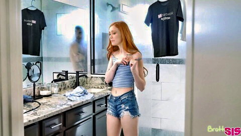 Scarlet Skies redhead in striped crop top and denim shorts posing in bathroom mirror