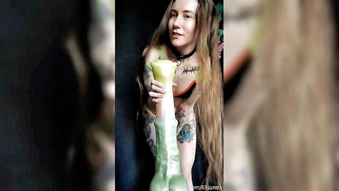 Tattooed blonde woman riding huge green dildo toy