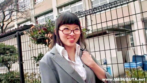 Smiling Asian office woman with glasses and bangs in gray blazer