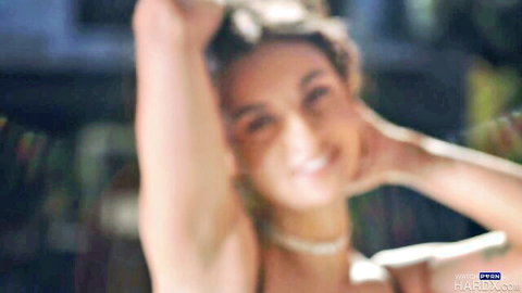 Hailey Rose smiling seductively with arms raised in HardX adult scene