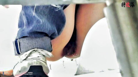 Asian woman peeing outdoors with jeans pulled down, close-up leg view