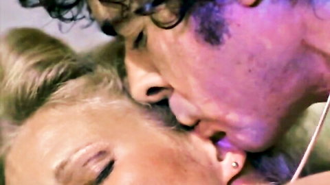 Vintage blonde babe passionately kissing curly-haired man close-up