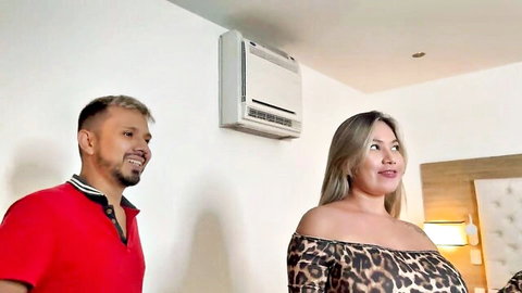 Sexy Asian MILF in leopard print top smiles with boyfriend in bedroom