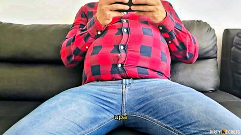 Chubby man sits on couch with shirt open and jeans unzipped exposing his cock and balls in selfie