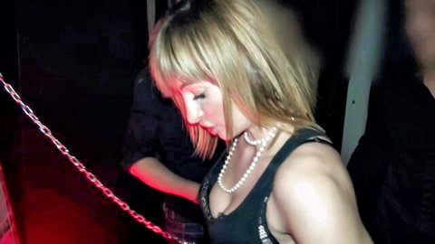 Blonde woman in low-cut tank top touched by man in dim club