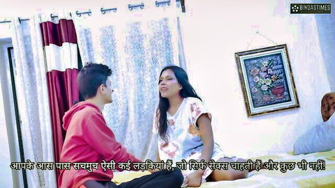 South Asian Indian couple in casual clothes chatting intimately on bed in bedroom