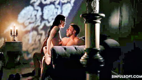 Brunette with long hair straddles muscular man on couch in intense eye contact and teasing lap ride