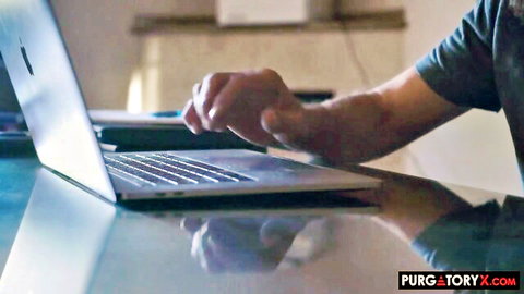 Man's hand typing on MacBook laptop keyboard on reflective glass desk