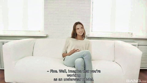 Sexy clothed babe sits on white couch during casting interview imagining underwear modeling
