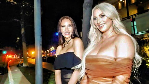 Kayley Gunner and Melissa Stratton in revealing off-shoulder dresses, busty blonde and brunette outdoors