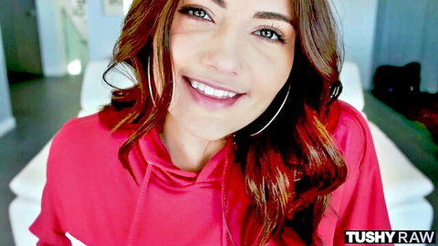 Smiling brunette beauty in pink hoodie teases with seductive gaze for Tushy Raw anal fun