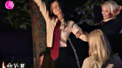 Blonde and brunette schoolgirls in uniforms dancing by campfire