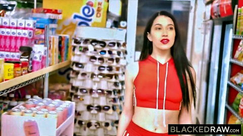 Sexy long-haired brunette in tight red tracksuit posing in convenience store