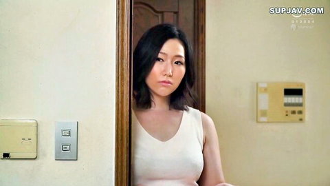 Asian brunette housewife in tight white tank top showing huge tits in bedroom doorway