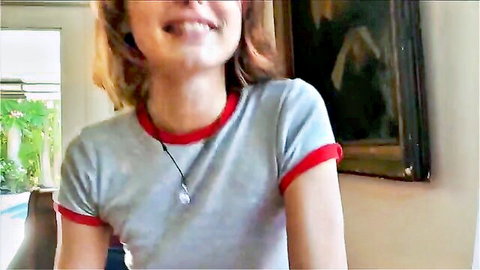 Smiling redhead babe in gray top with red trim flashing happy grin closeup