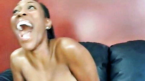 Ebony babe moaning mouth wide open topless with big shiny tits on couch