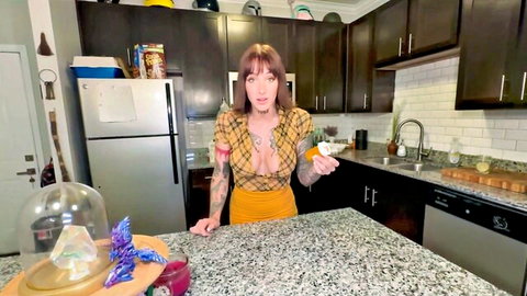 Busty tattooed redhead MILF in low-cut yellow top teasing huge cleavage holding pill bottle in kitchen