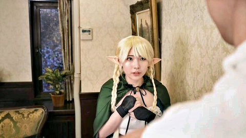 Blonde elf cosplay Japanese girl in green cape grabs her tits with gloved hands as man approaches from behind
